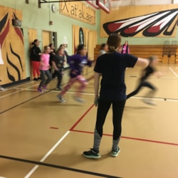 Girls on the run coach with hand on hip